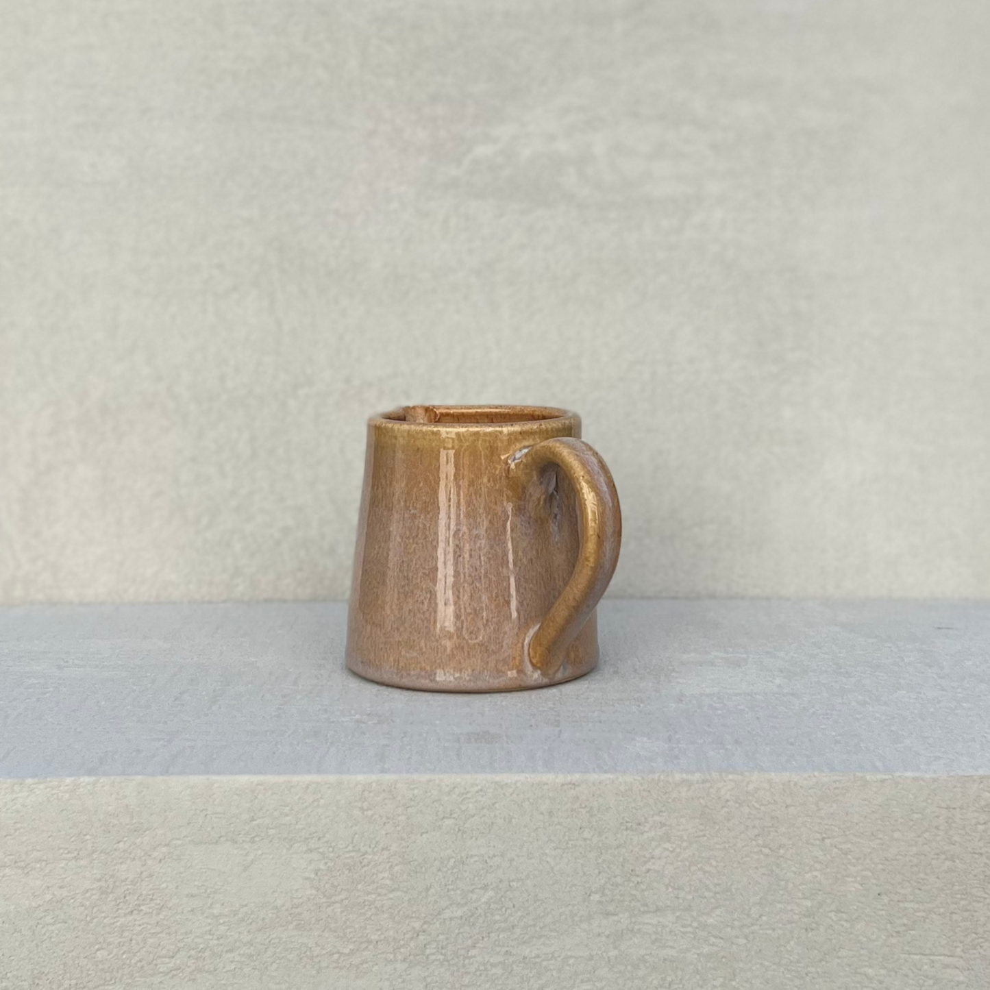 Beige ceramic milk jug that is hand made with a glazed finish