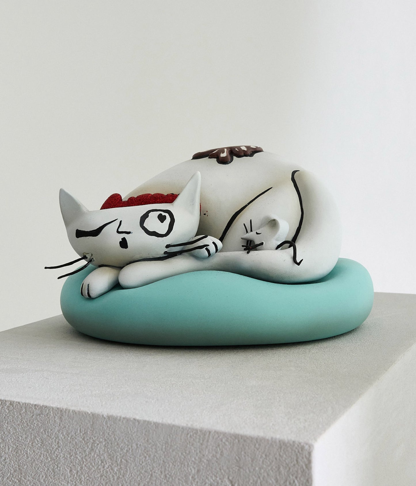 curled up cat sculpture on cushion from fortnum and mason display