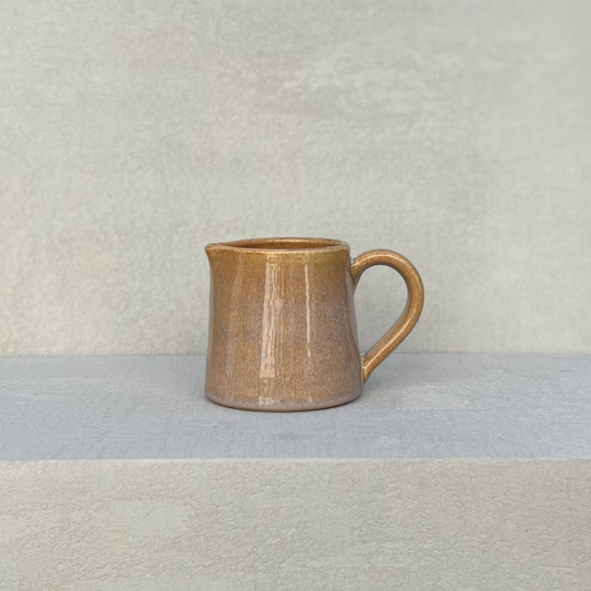 Hand made glazed ceramic milk jug in beige