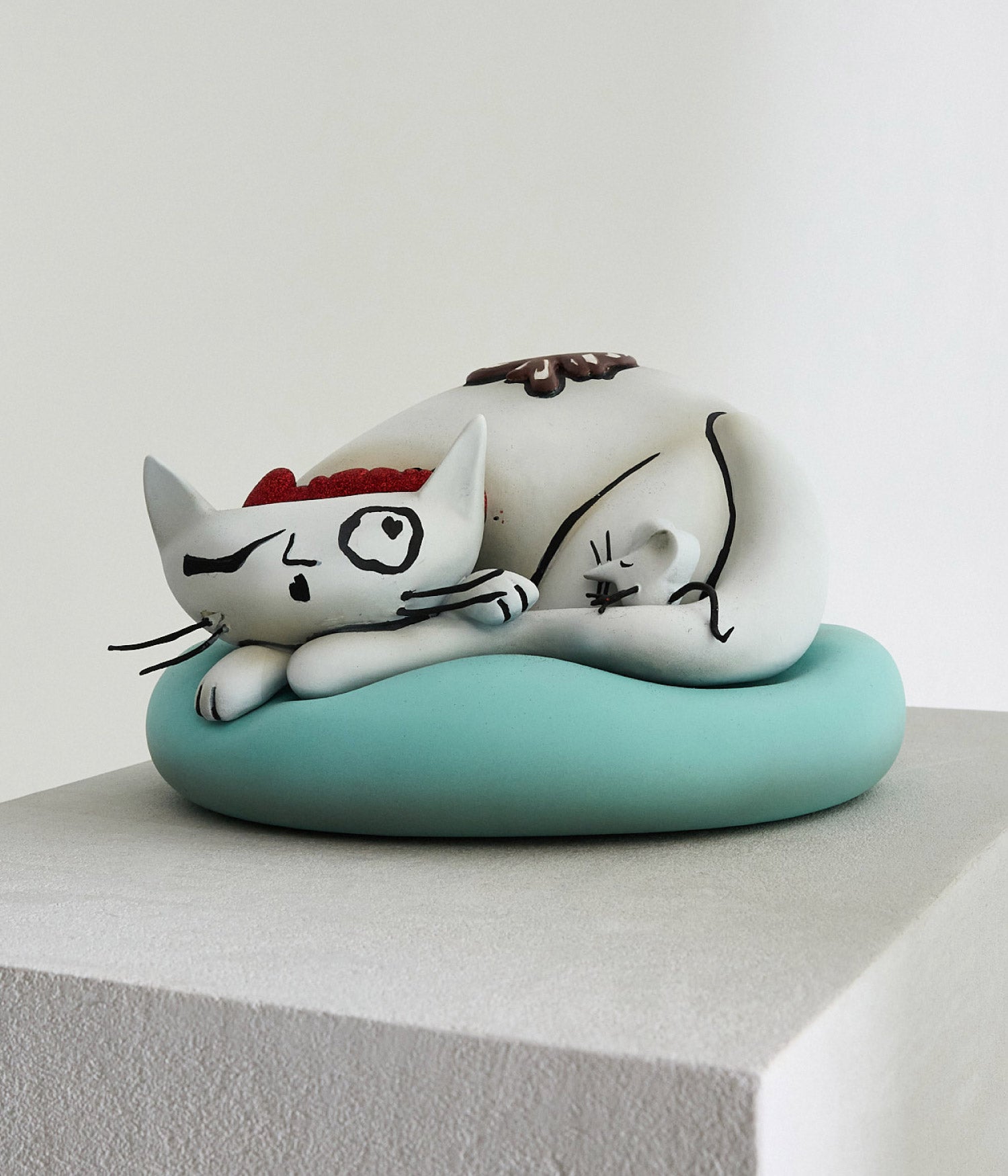 curled up cat sculpture on cushion from fortnum and mason display